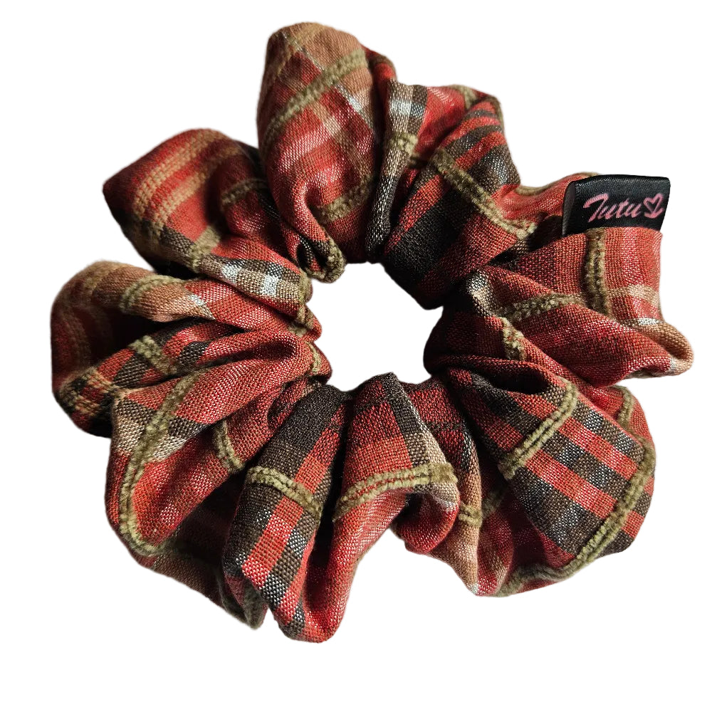 A fabric hair scrunchie with a orange, brown, and beige plaid pattern on a white background. A small black brand tag reading 'Tutu22' is visible on the right side.