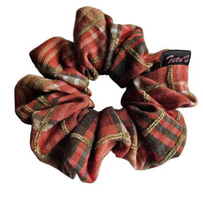 A fabric hair scrunchie with a orange, brown, and beige plaid pattern on a white background. A small black brand tag reading 'Tutu22' is visible on the right side.