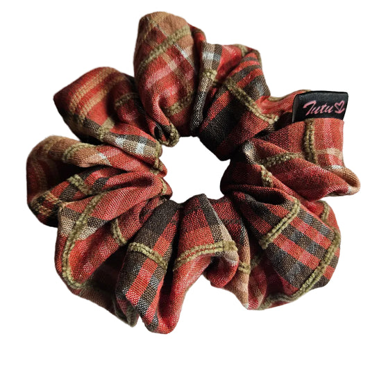 A fabric hair scrunchie with a orange, brown, and beige plaid pattern on a white background. A small black brand tag reading 'Tutu22' is visible on the right side.