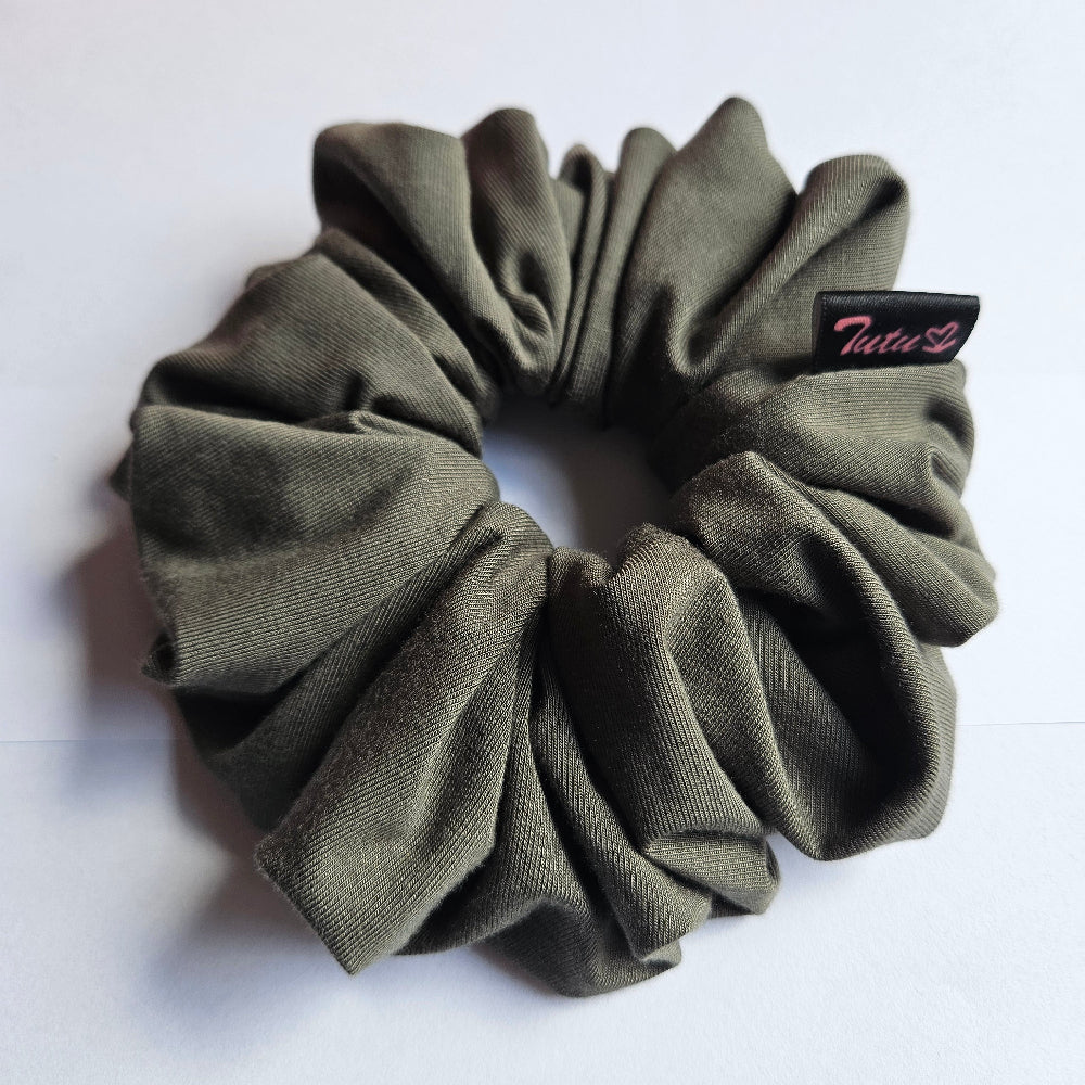 An olive green fabric scrunchie with a small black brand tag that reads 'Tutu22', photographed on a plain white surface.