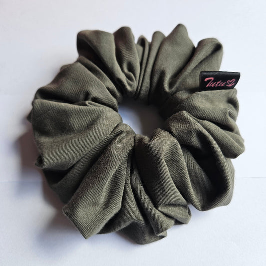 An olive green fabric scrunchie with a small black brand tag that reads 'Tutu22', photographed on a plain white surface.